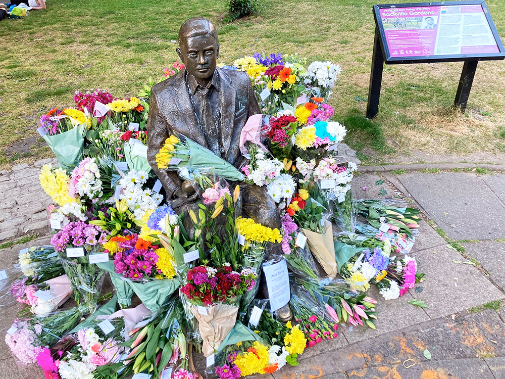 Statue of seated man surrounded by flowers